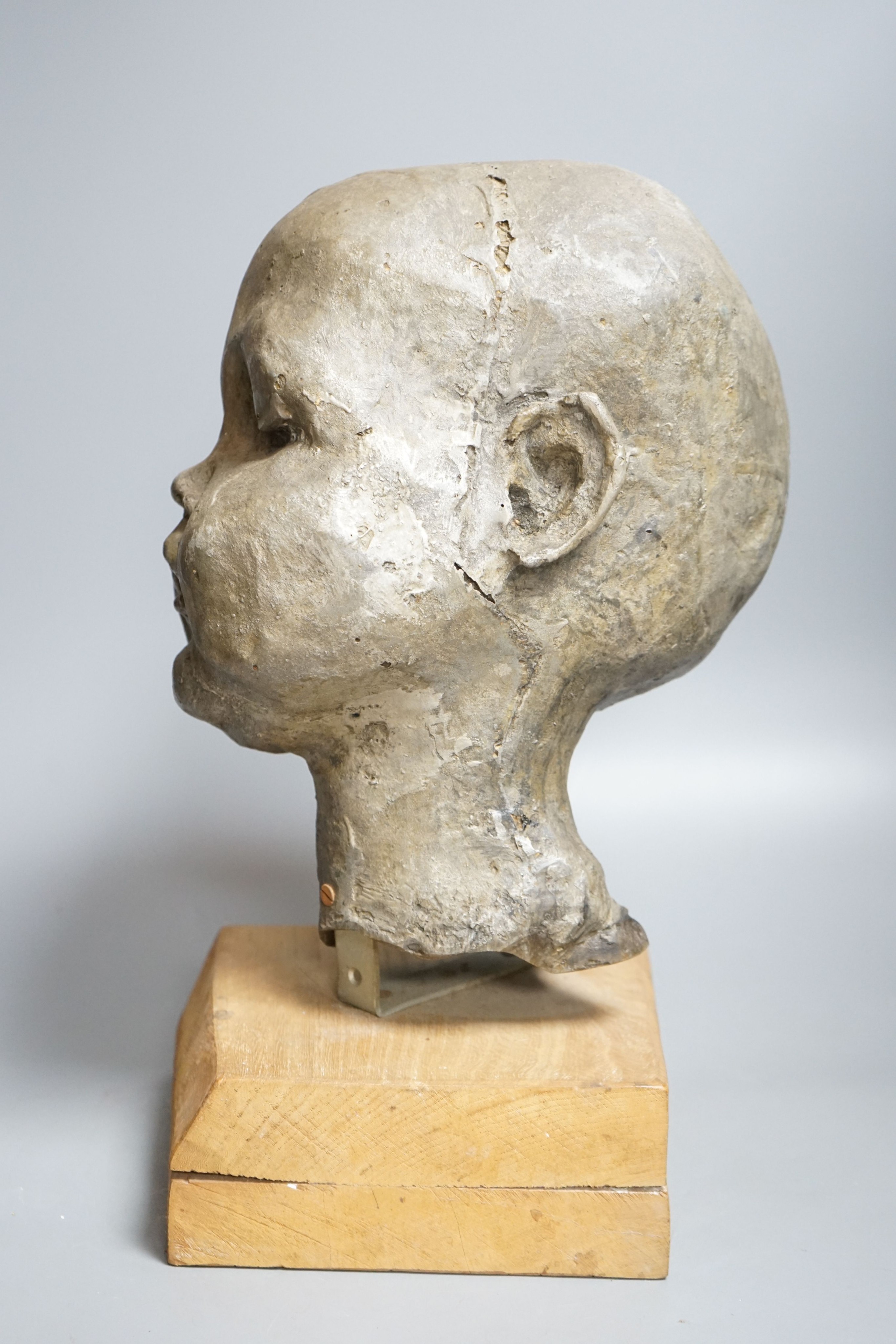 A composition sculpture of a child’s head 40 cm high including plinth